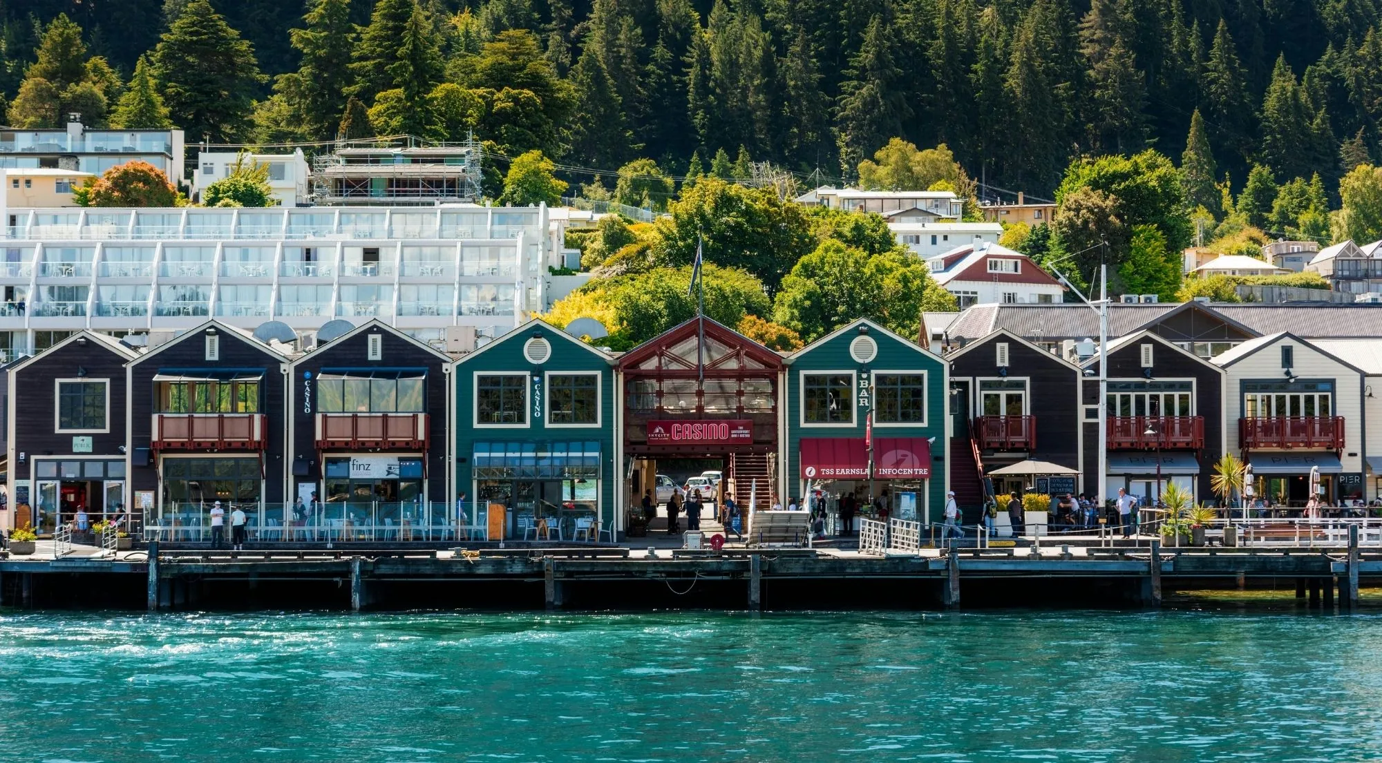 Queenstown's waterfront buildings in a row along the lake edge, with bush behind
