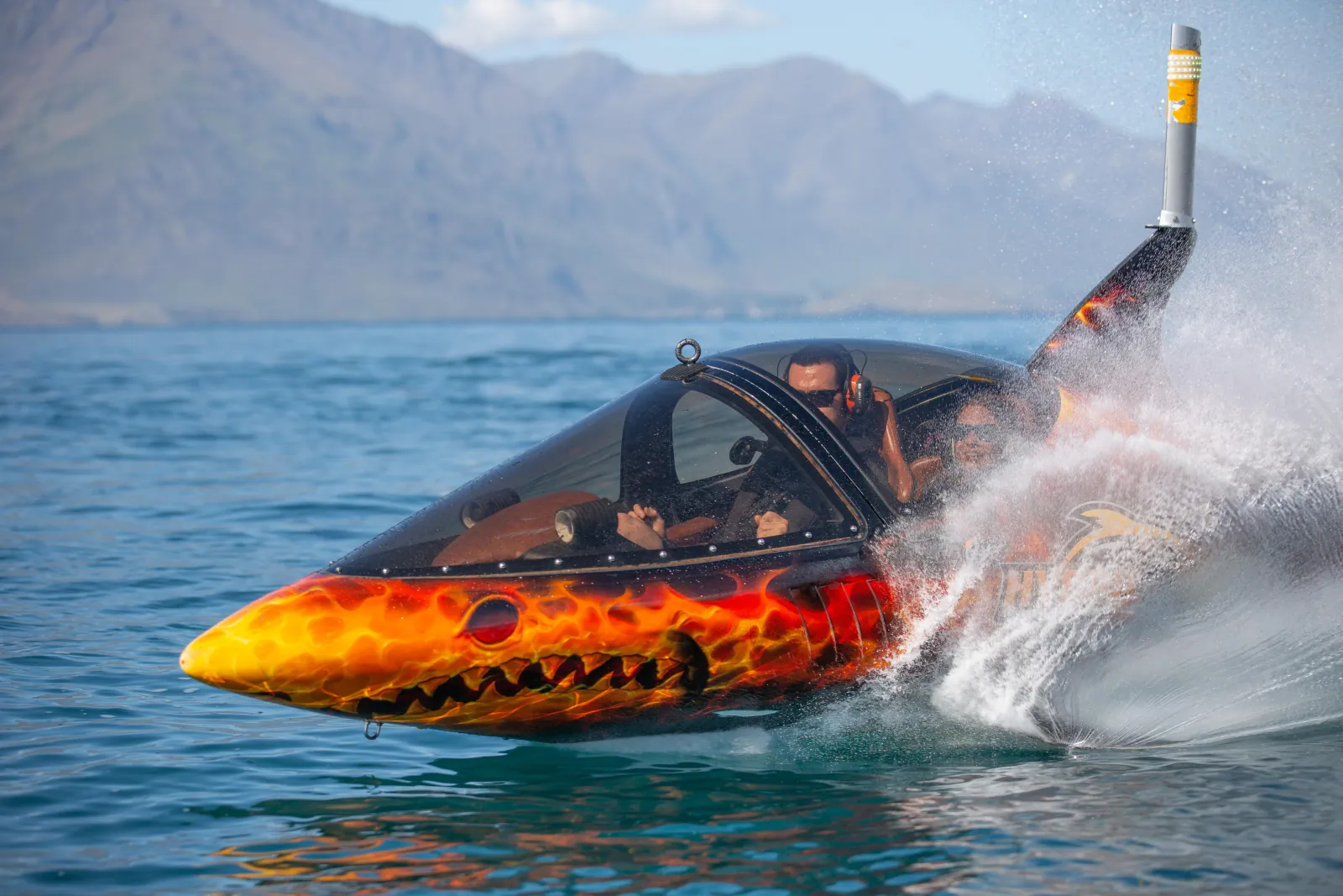 The semi-submersible craft nose-down and half submerged, throwing spray