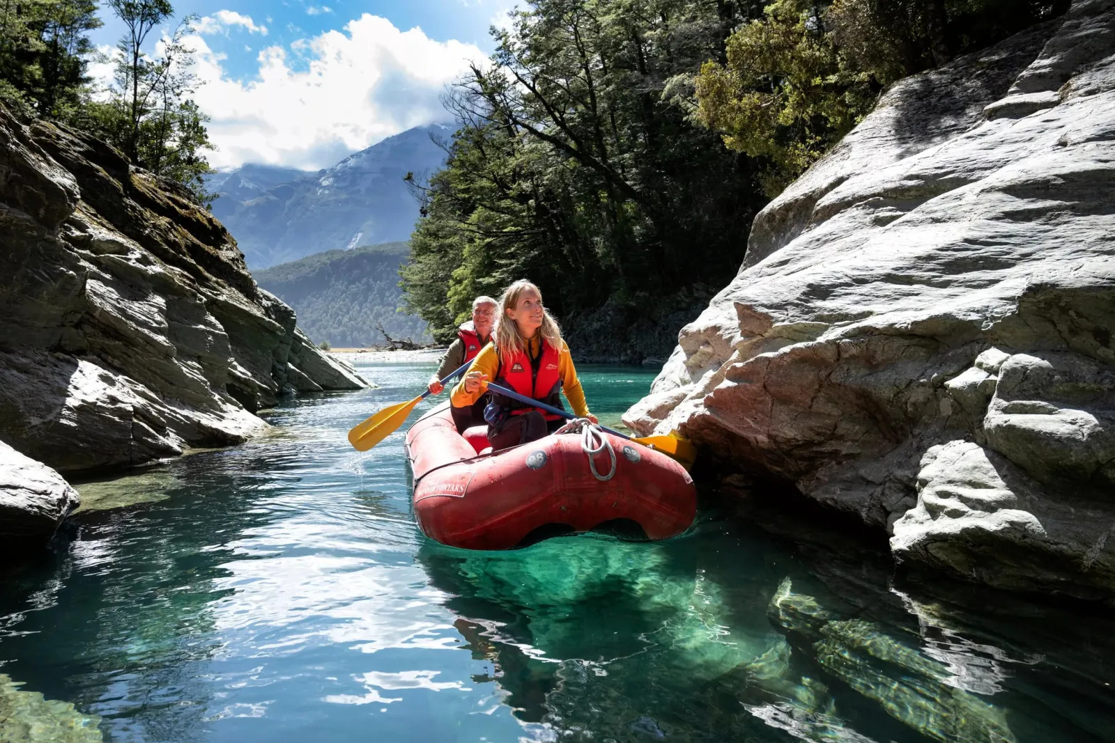 A paddler in a red Funyak working through a rocky side stream
