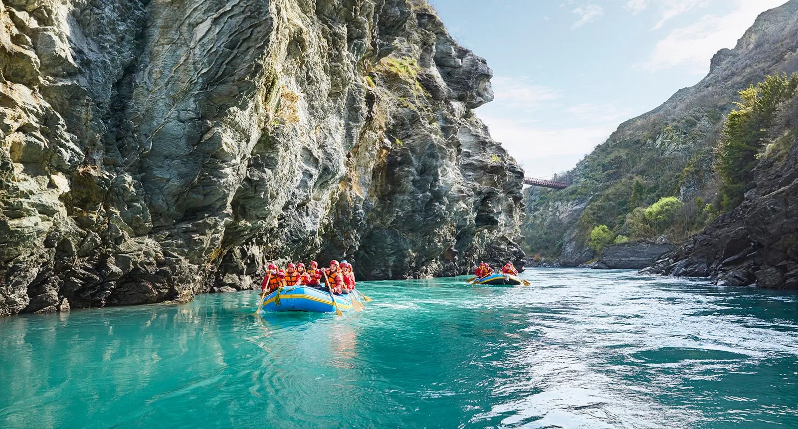 Rafts moving down a steep-sided canyon in a line
